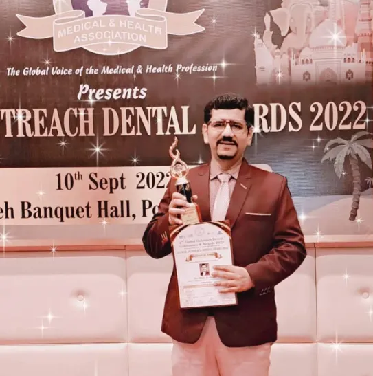 Dr. Millin D. Desai holding Outreach Dental Award 2022